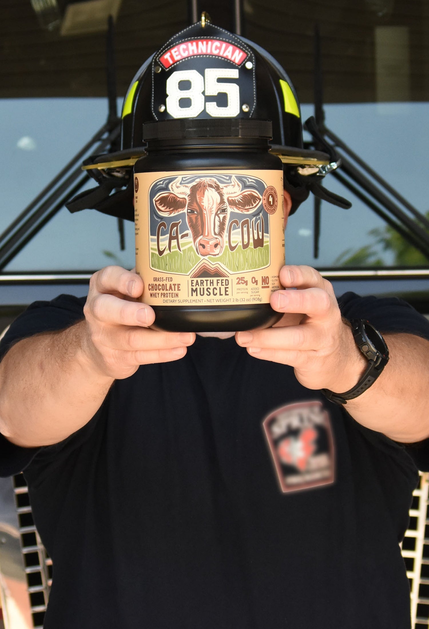 Firefighter holding Earth Fed Muscle ca-cow protein powder