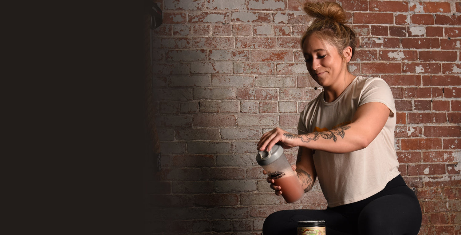 Girl mixing stimulant free Stammpede sour cherry pre-workout in a shaker bottle